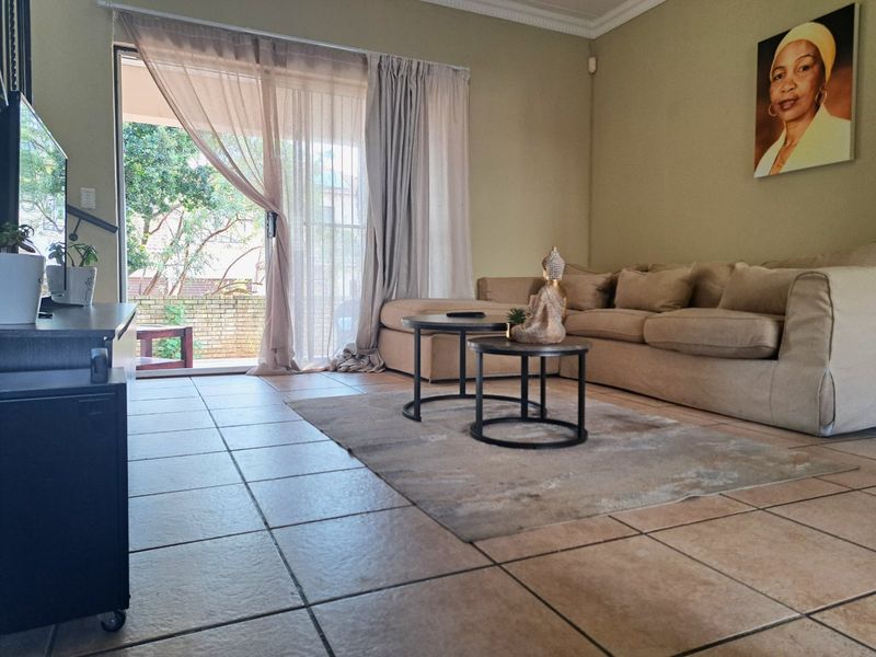 A living room featuring tiled flooring and a sliding glass door providing access to an outdoor area.