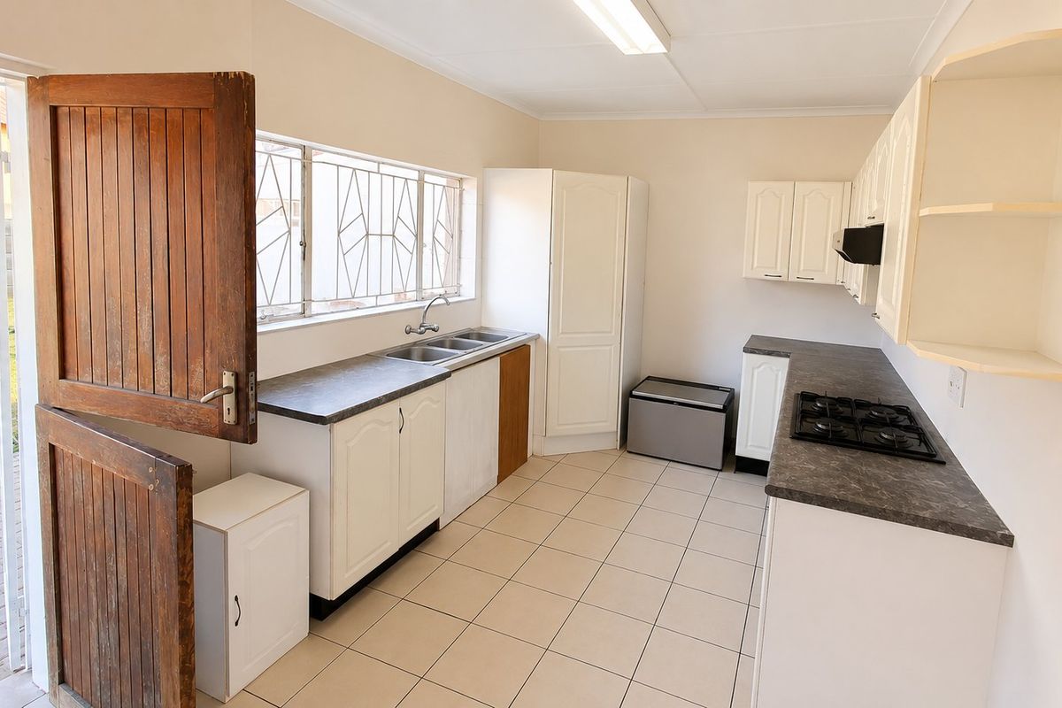 Functional kitchen featuring white cabinetry, laminate countertops, gas hob, and tiled flooring, with direct access to the exterior via a stable door.