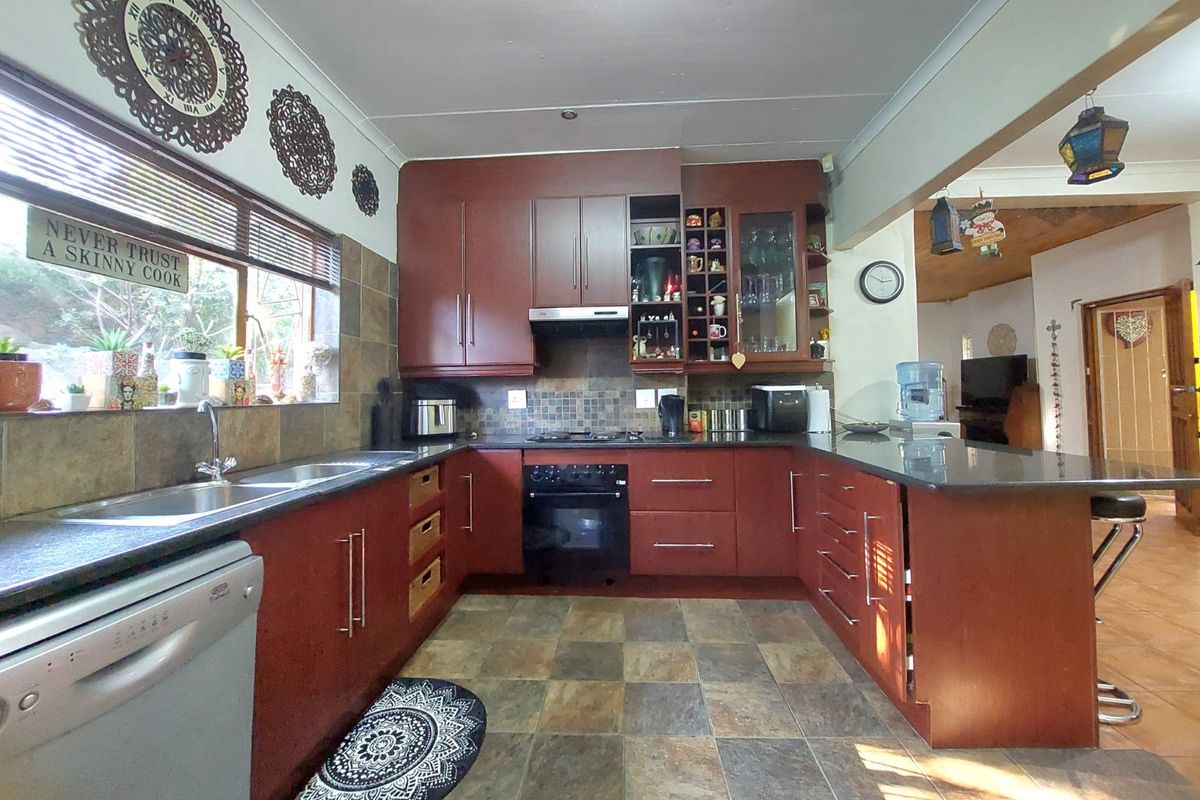 A functional kitchen featuring dark wood cabinetry, stone countertops, a built-in oven with gas hob, and tiled flooring with a tiled backsplash.