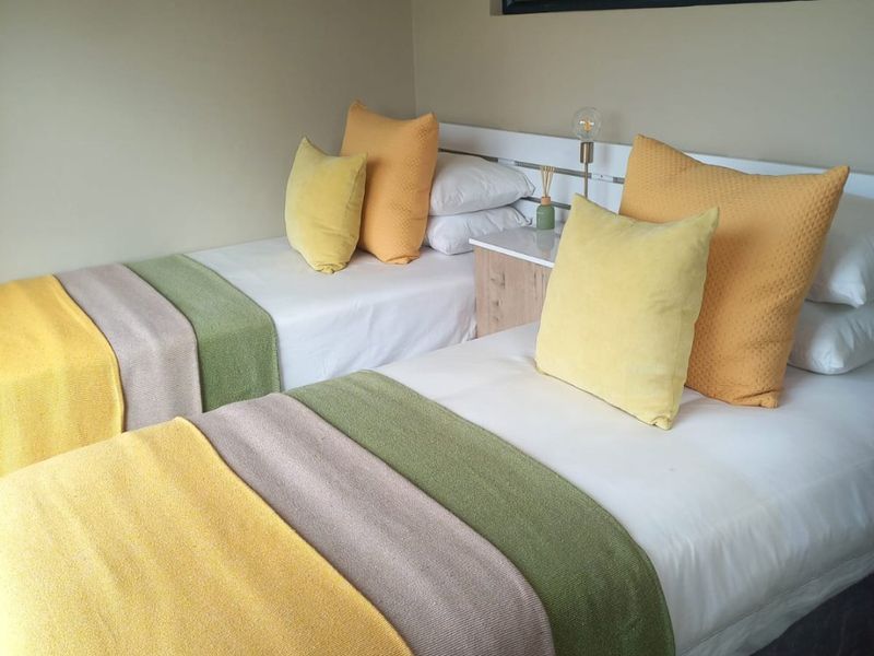 A well-maintained bedroom featuring a built-in headboard and durable laminate flooring, offering a clean and functional living space.
