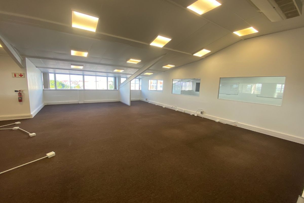 Spacious open-plan commercial office area featuring recessed lighting, air conditioning, and large windows providing natural light.