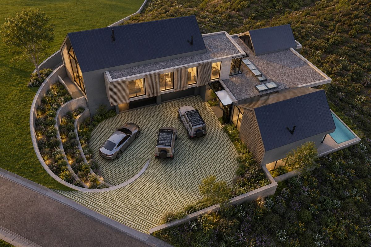 Aerial view of a modern architectural house featuring a metal roof, integrated skylights, a paved driveway, and a private swimming pool.