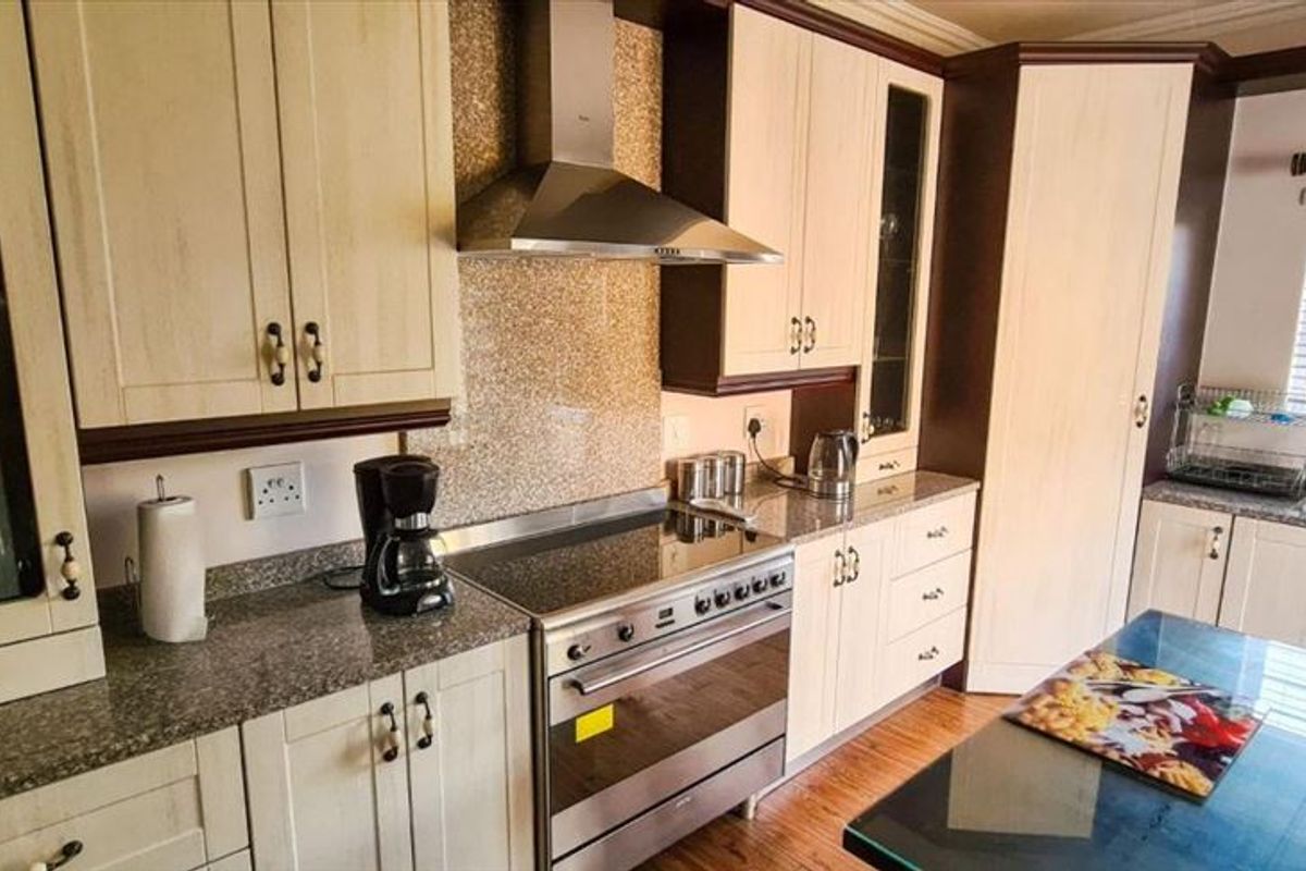 A well-maintained kitchen featuring granite countertops, stainless steel appliances, ample cabinetry, and a functional layout with a central island.