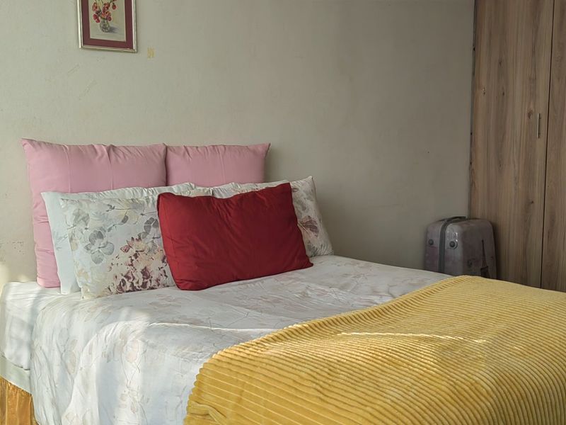 A functional bedroom featuring a built-in wardrobe with ample storage space and neutral wall finishes.