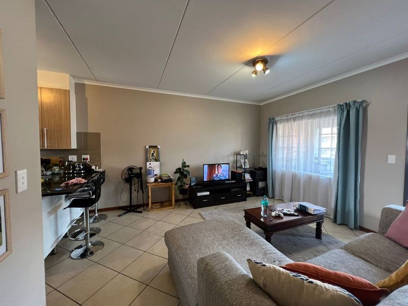 Open plan living area featuring tiled flooring and a kitchen with granite countertops, creating a functional and connected space for daily living.