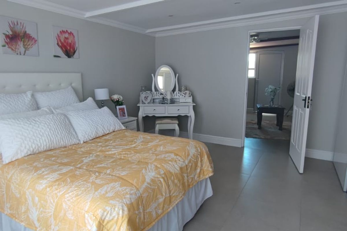 A well-maintained bedroom featuring neutral wall tones, tiled flooring, recessed ceiling lighting, and built-in wardrobe cabinetry.