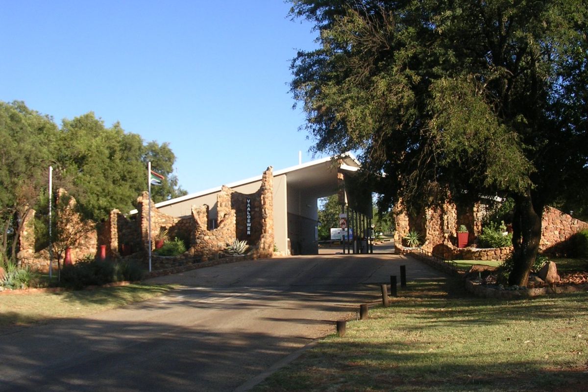The entrance to the Vaaloewer residential estate, featuring a stone-clad gatehouse structure and paved access road.