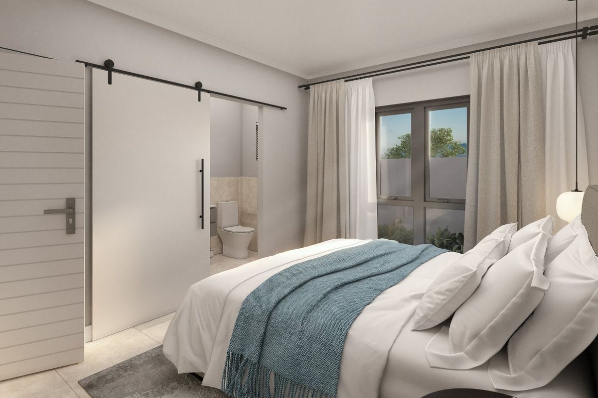 A modern bedroom featuring a sliding barn door leading to an en-suite bathroom, large windows, and contemporary finishes.