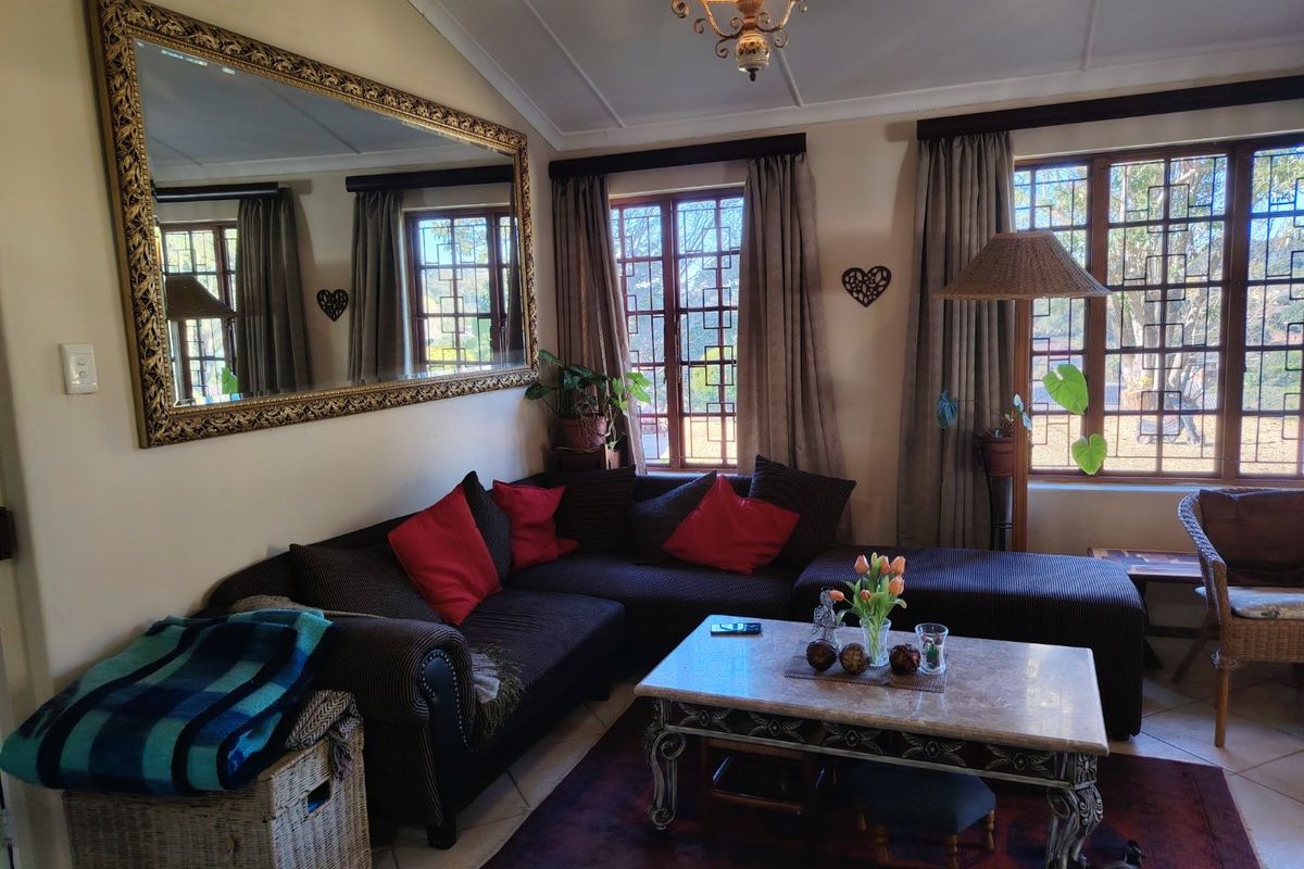 A cozy living room featuring large windows with decorative lattice detailing, vaulted ceilings, and tiled flooring.