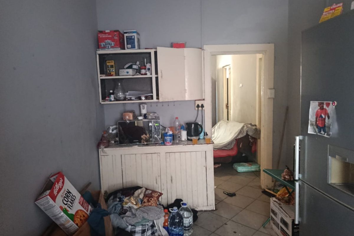 A small kitchen area featuring basic built-in cabinetry and tiled flooring, requiring significant renovation and cosmetic updates to improve functionality and aesthetic appeal.