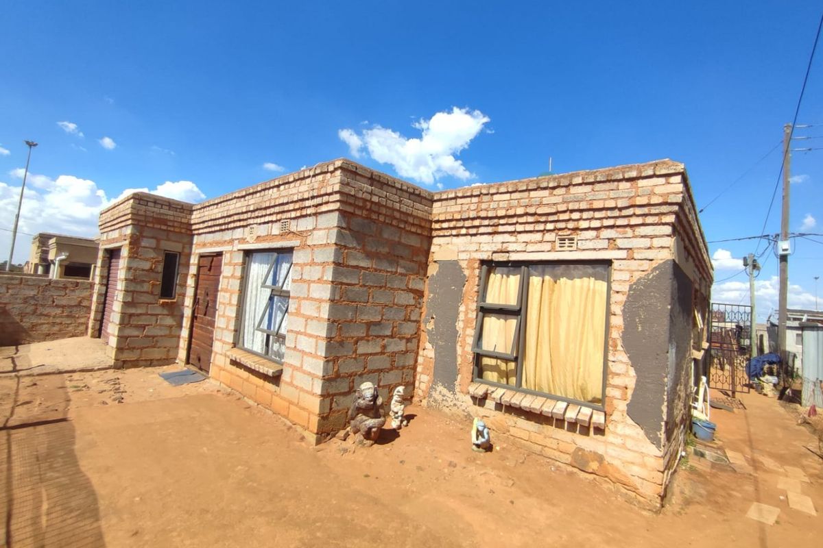 A single-story residential property featuring exposed brick construction, requiring exterior finishing and maintenance to improve its structural appearance and curb appeal.