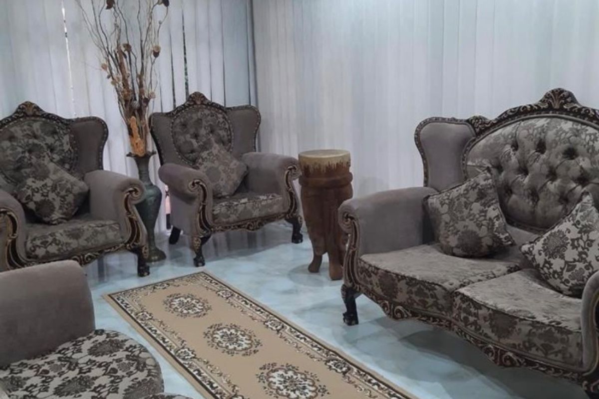 A formal living room featuring tiled flooring, vertical blinds, and a ceiling fan.