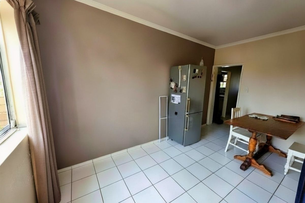 A functional dining area featuring tiled flooring and neutral wall tones, providing a practical space for meals.
