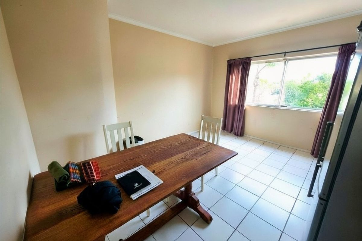 A functional dining area featuring tiled flooring and a large window that provides natural light.