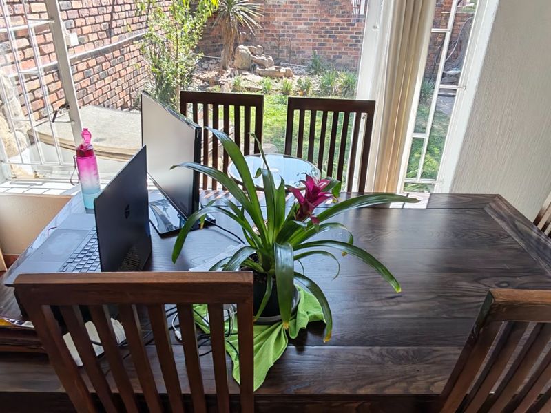 Dining area featuring large sliding glass doors with security gates, providing natural light and direct access to the rear garden.