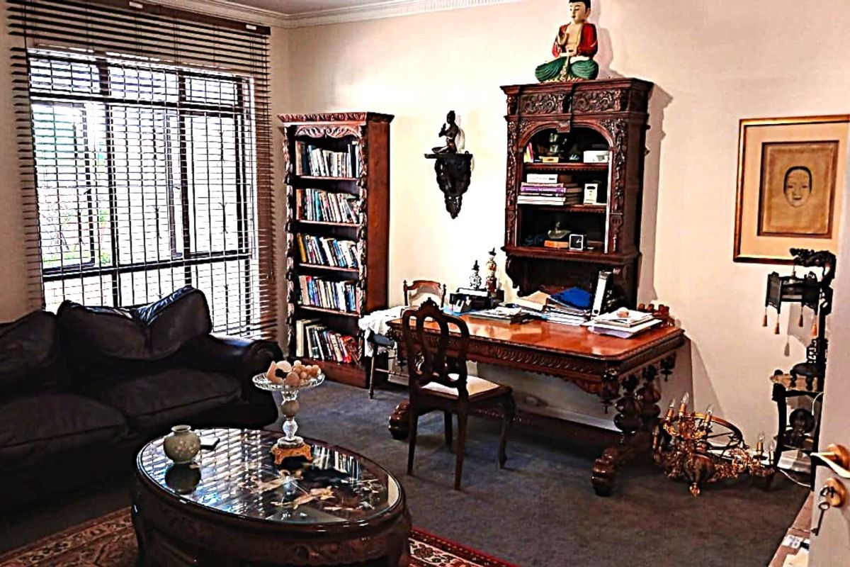 A living room or study area featuring carpeted flooring, coving, and venetian blinds on the window.