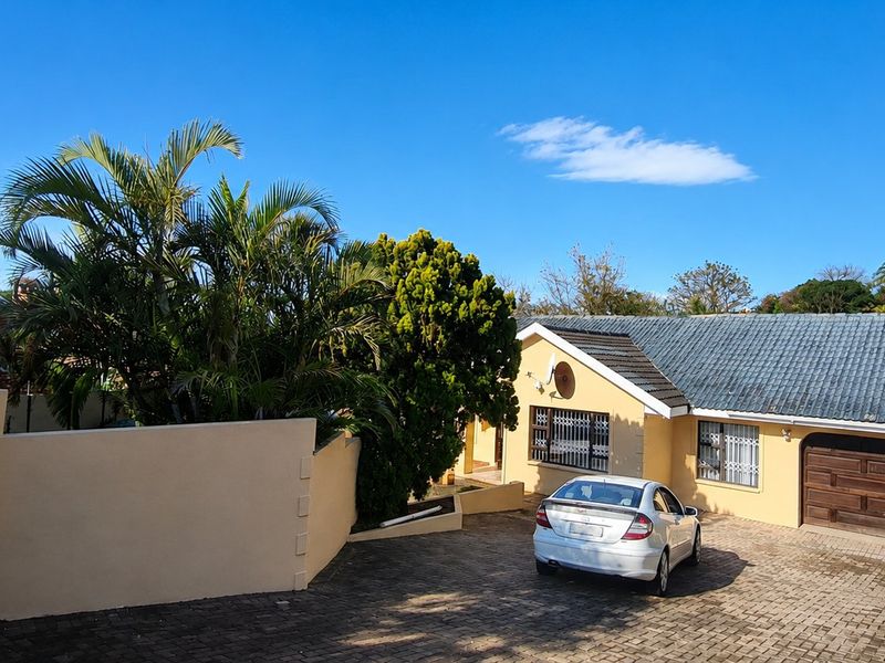 Front exterior view of a single-story house featuring a paved driveway, tiled roof, and secure garage access.