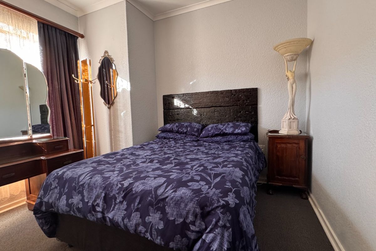 A standard bedroom featuring carpeted flooring and coved ceiling details, providing a functional space for rest.