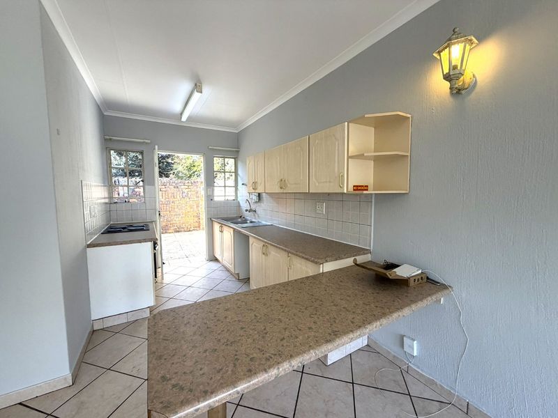 Functional kitchen featuring built-in cabinetry, laminate countertops, a breakfast bar, and direct access to an outdoor area.