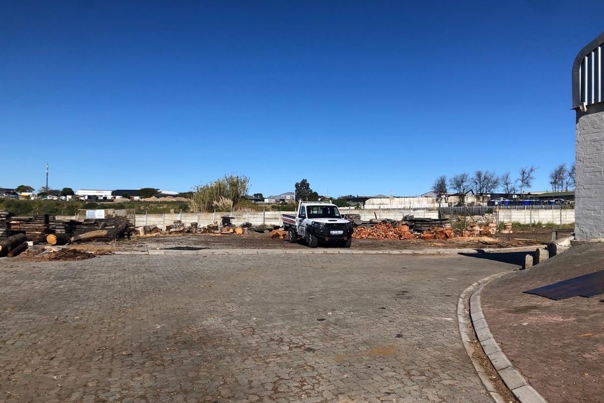 Spacious industrial yard area featuring paved surfacing and secure perimeter walling, suitable for storage or operational use.