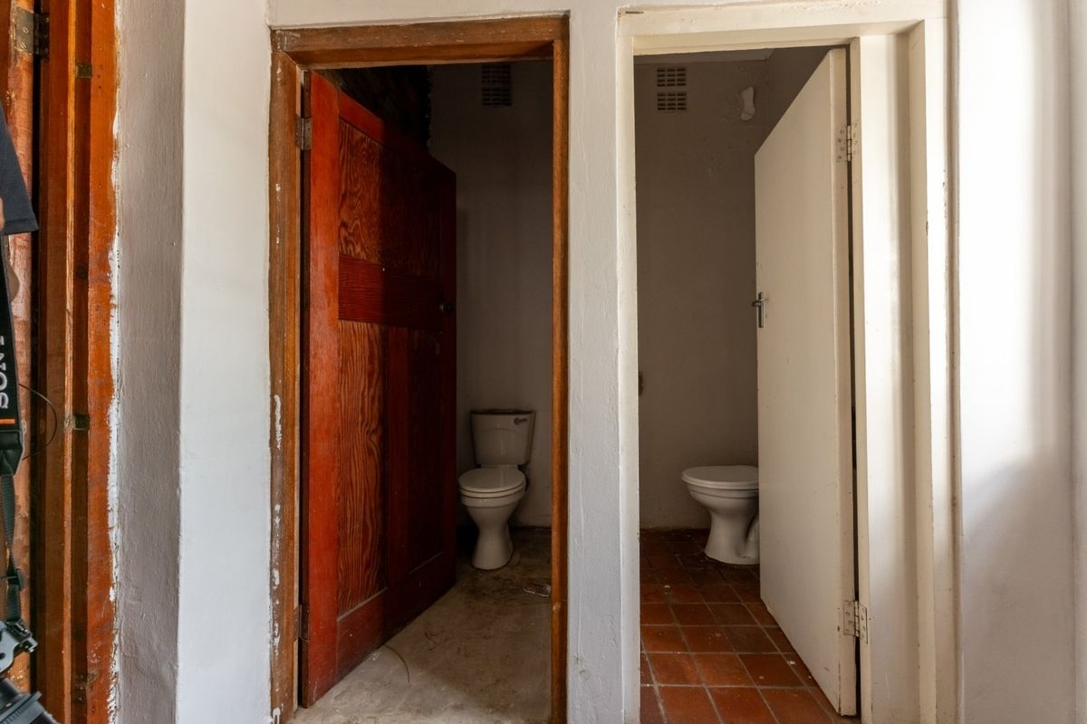 Two separate toilet cubicles featuring basic sanitary ware and tiled flooring, requiring renovation and cosmetic updates.