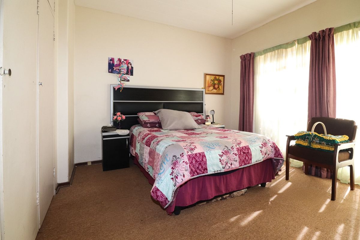 A bedroom featuring built-in cupboards and carpeted flooring, offering a functional space with potential for cosmetic updates to enhance its appeal.