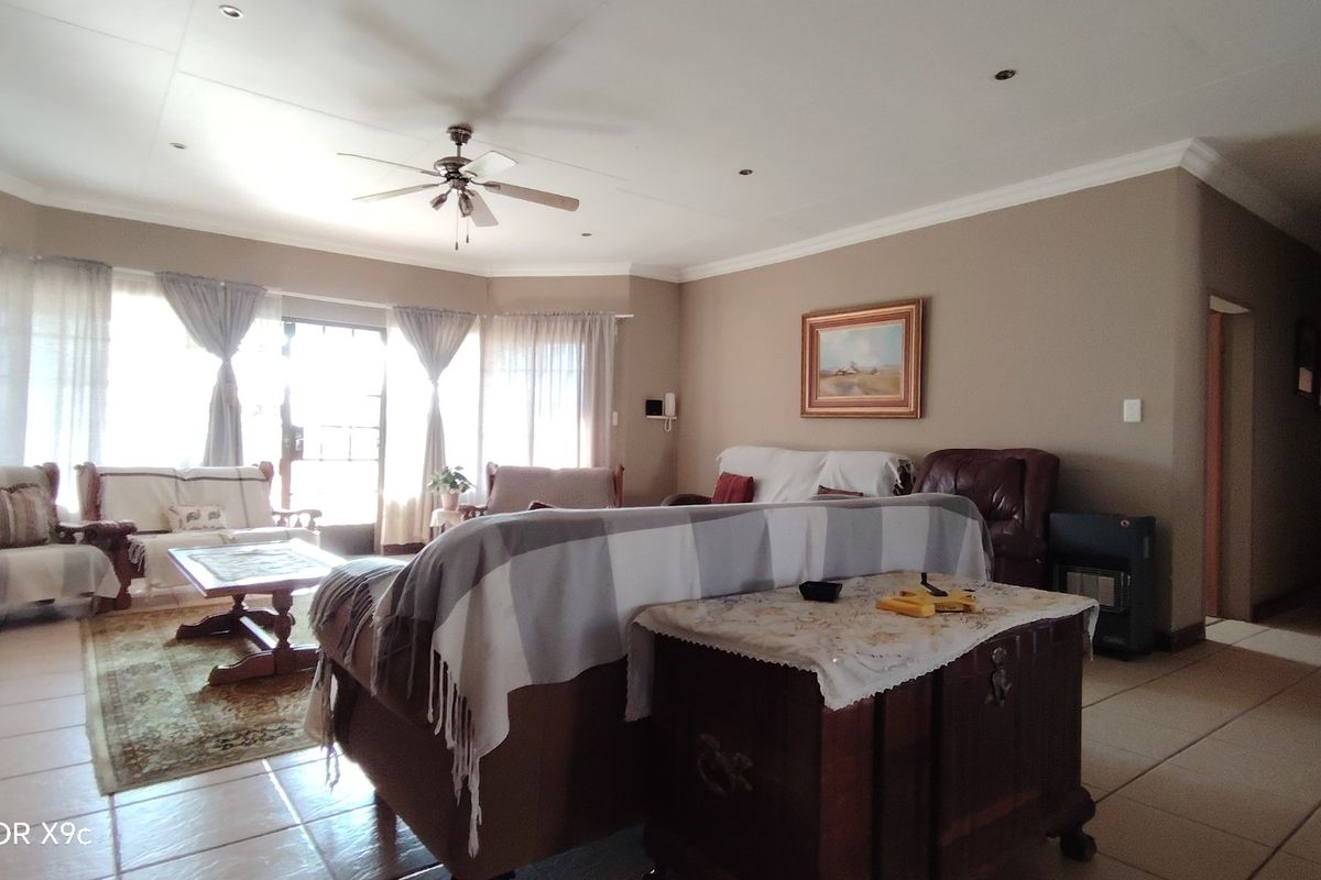 Spacious living room featuring tiled flooring, recessed lighting, a ceiling fan, and large sliding glass doors providing ample natural light.