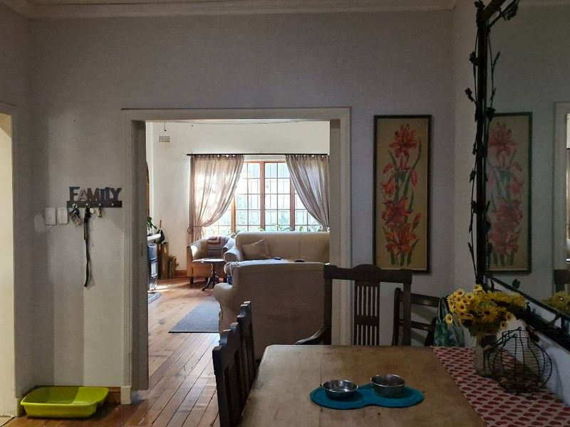 Open plan living and dining area featuring warm timber flooring and built-in cabinetry, providing a functional and connected layout.