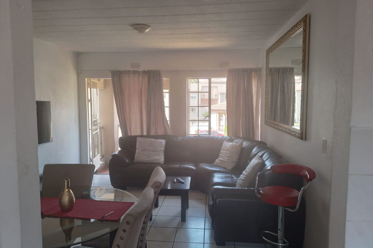 Open-plan living and dining area featuring tiled flooring and access to an outdoor balcony space.