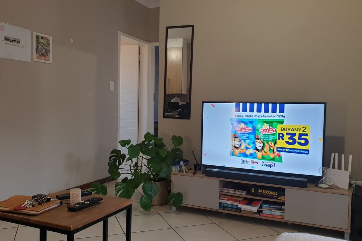 A living room area featuring neutral wall tones and tiled flooring, providing a functional space for relaxation and entertainment.