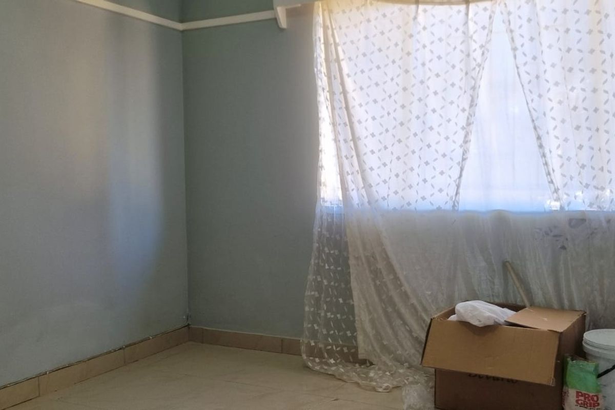 An empty bedroom featuring tiled flooring and a classic picture rail, presenting a blank canvas ready for renovation or restyling.