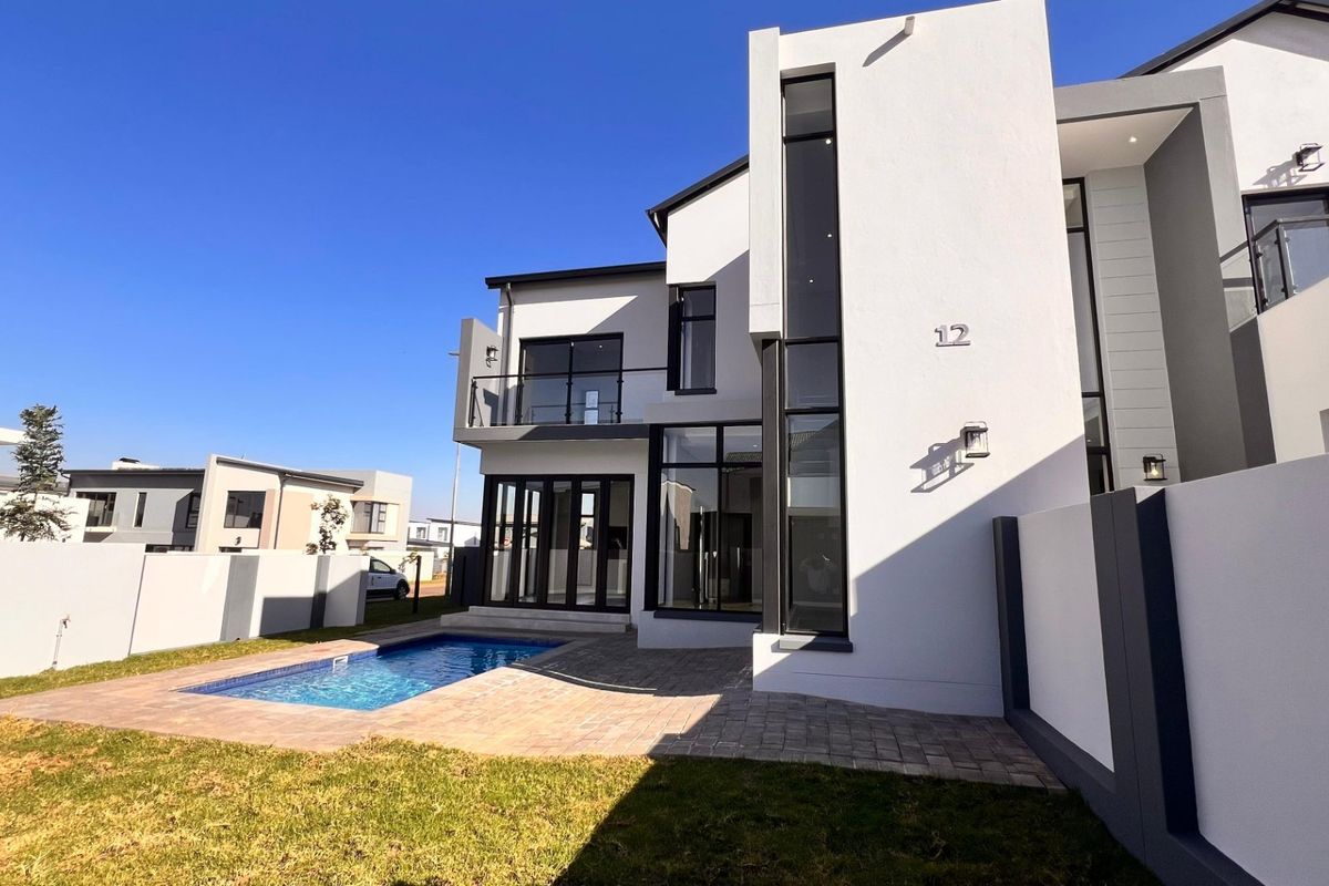 Modern double-story residence featuring a rear patio, private swimming pool, and contemporary architectural design with large glass windows.