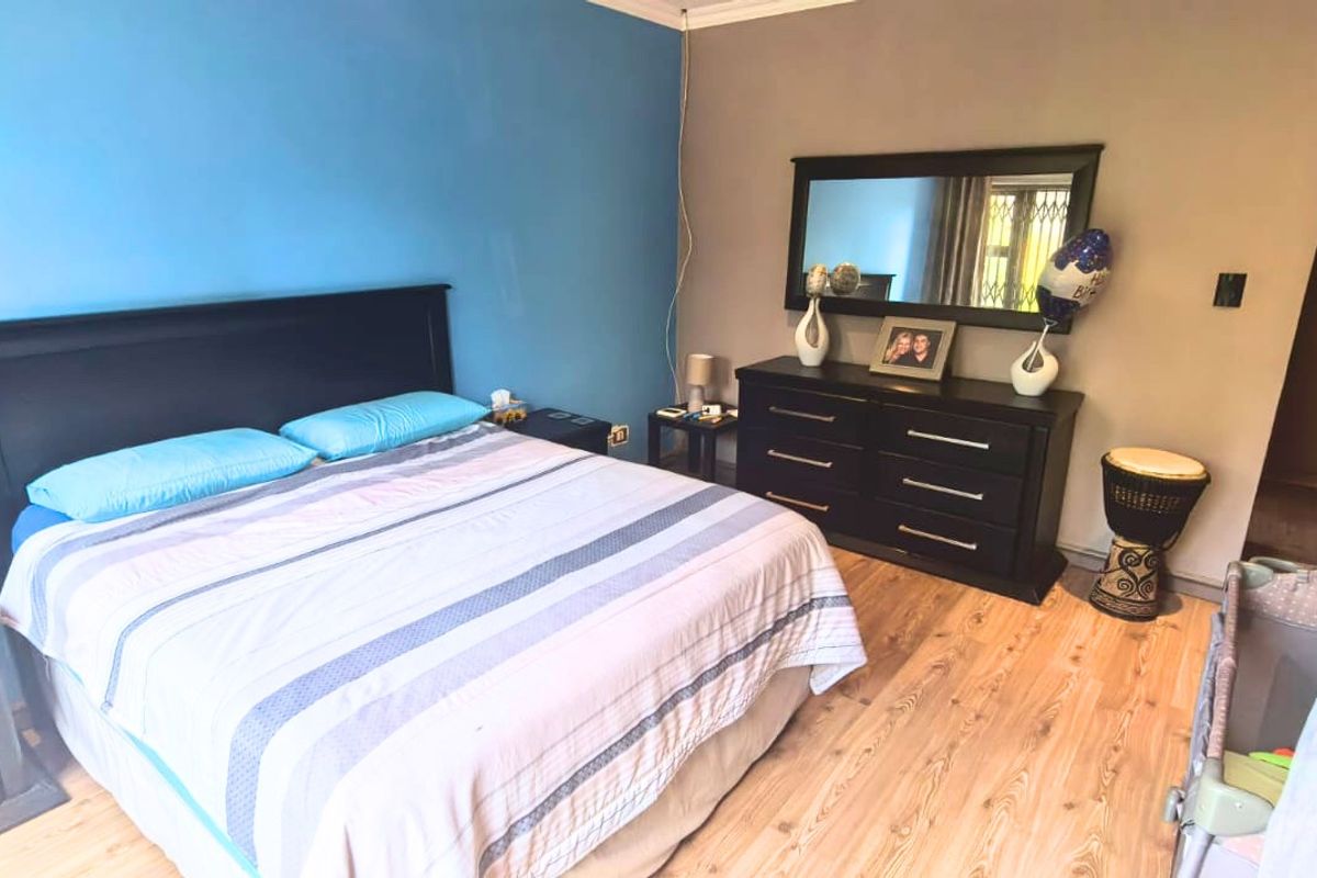 A spacious bedroom featuring laminate flooring and built-in cupboards, offering a comfortable and functional living space.