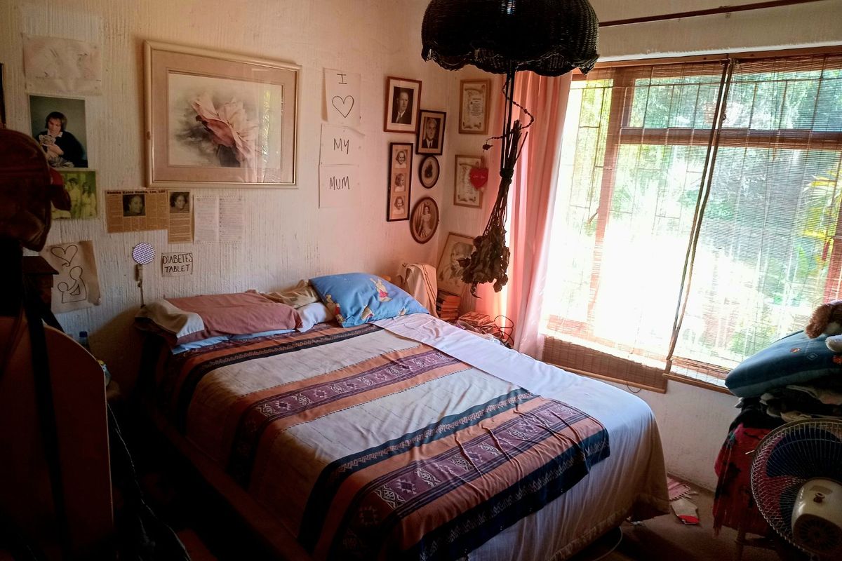 A bedroom featuring a large window with natural light and textured wall finishes.
