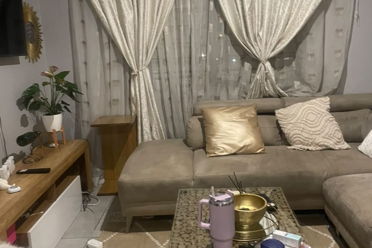 A cozy living room featuring tiled flooring and window treatments, providing a comfortable space for relaxation.