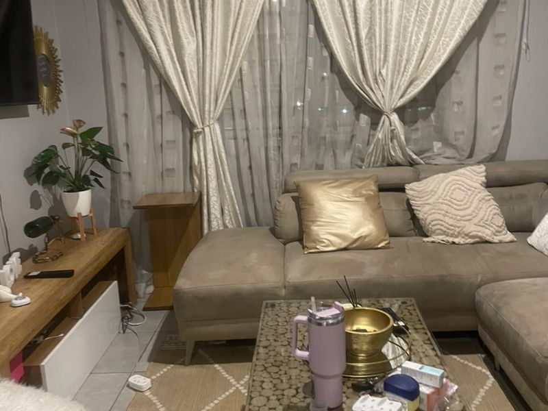 A cozy living room featuring tiled flooring and window treatments, providing a comfortable space for relaxation.