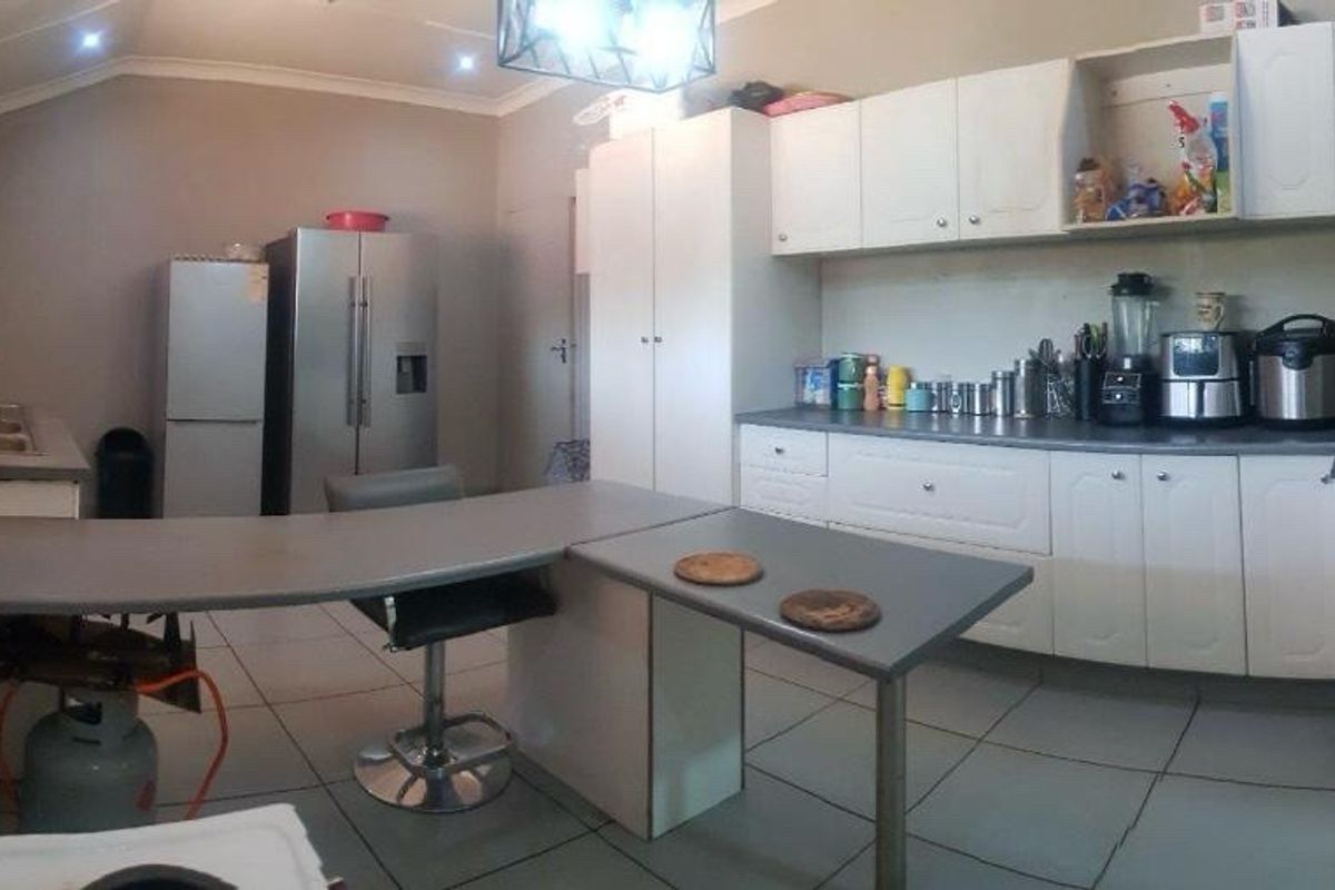Functional kitchen featuring white cabinetry, laminate countertops, tiled flooring, and recessed lighting, offering a practical layout for daily meal preparation.