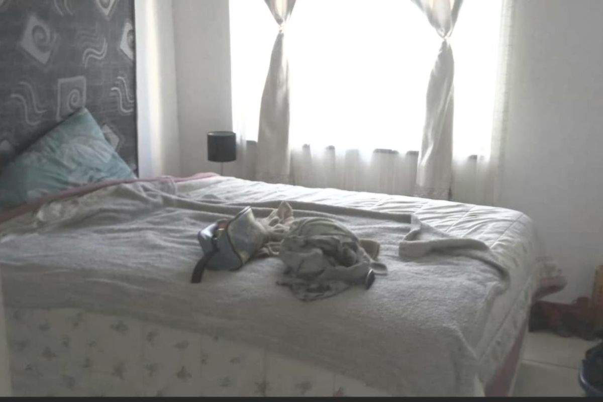 A bedroom featuring a decorative wall panel behind the bed area with natural light from the window.