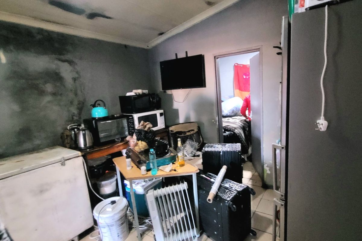 A kitchen area showing significant signs of wear, including wall staining and ceiling damage, requiring substantial renovation and repair to restore functionality.