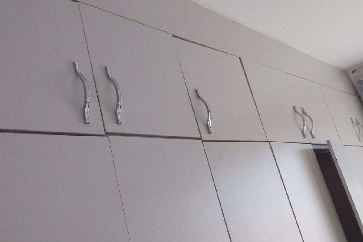 A view of modern, neutral-toned built-in cupboards providing ample storage space within the bedroom.
