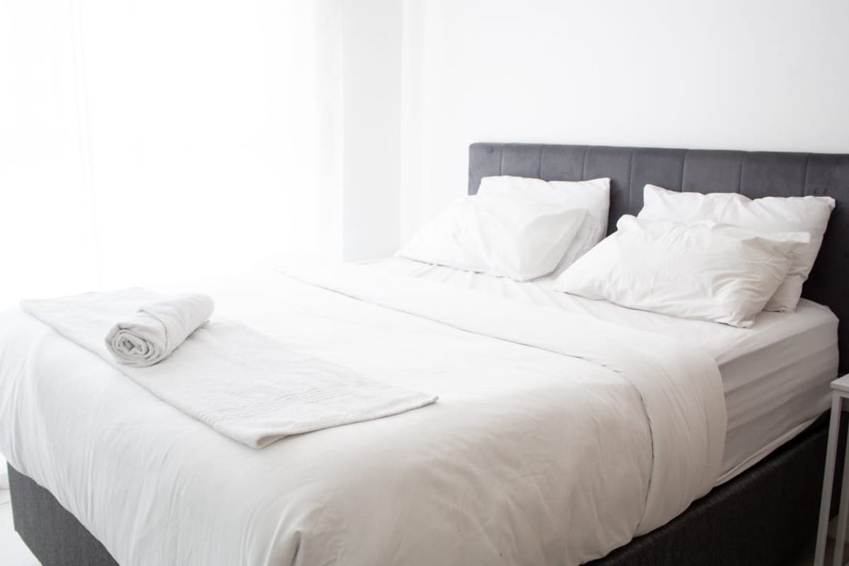 A clean and bright bedroom featuring neutral finishes and a modern aesthetic.