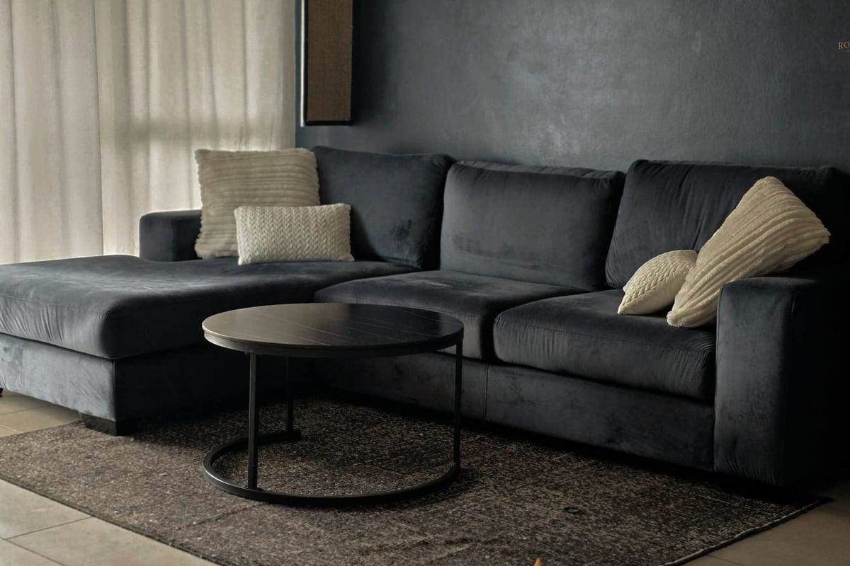 A comfortable living room area featuring tiled flooring and a dark accent wall, providing a modern and cozy atmosphere.