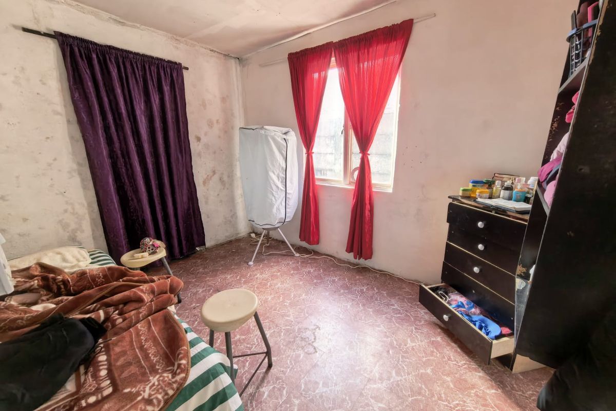 A bedroom featuring worn flooring and walls in need of repair and repainting, offering a blank canvas for renovation.
