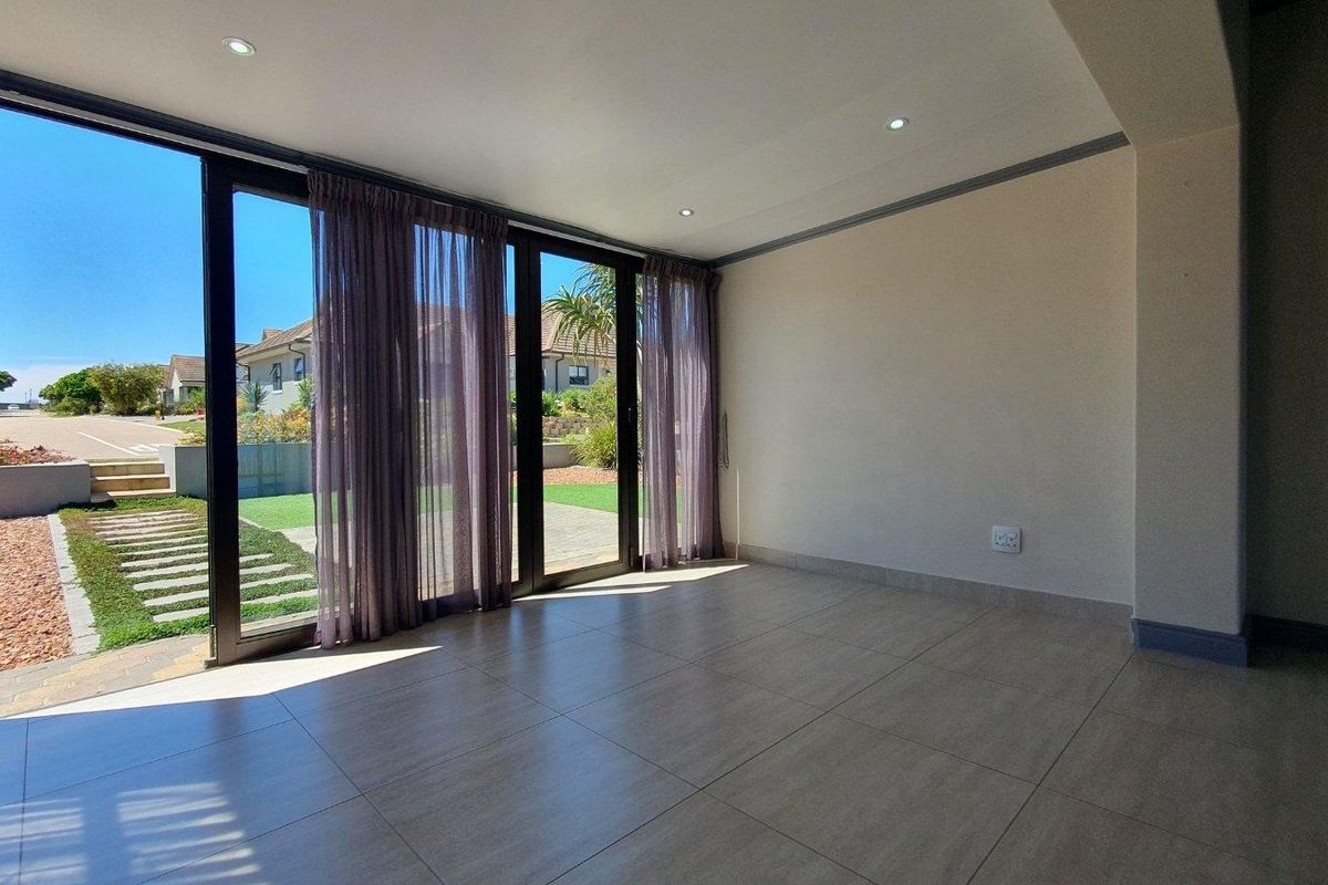 Bright and spacious living area featuring large sliding glass doors that provide seamless access to the outdoor garden space.