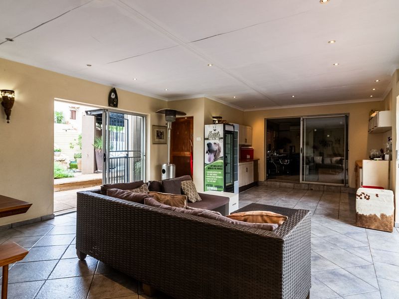 Spacious covered patio area featuring tiled flooring, recessed lighting, and sliding glass doors providing seamless access to the outdoor garden space.