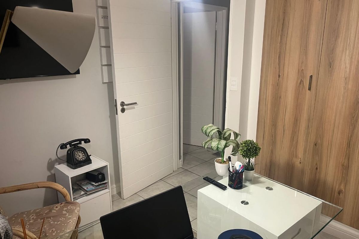 A bedroom featuring tiled flooring, a built-in wardrobe with wood-grain finish, and a modern internal door leading to a hallway.