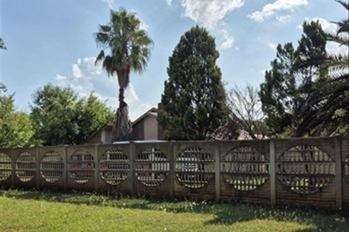 Front view of the property featuring a decorative precast concrete boundary wall and established garden area.