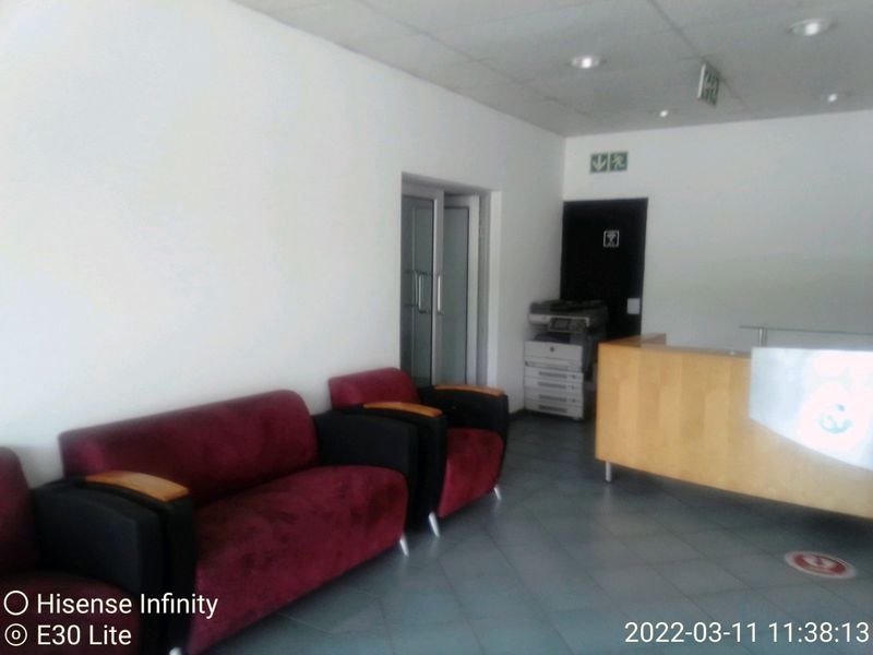 Commercial reception area featuring a built-in reception desk, tiled flooring, and recessed lighting, providing a functional entry space for clients.