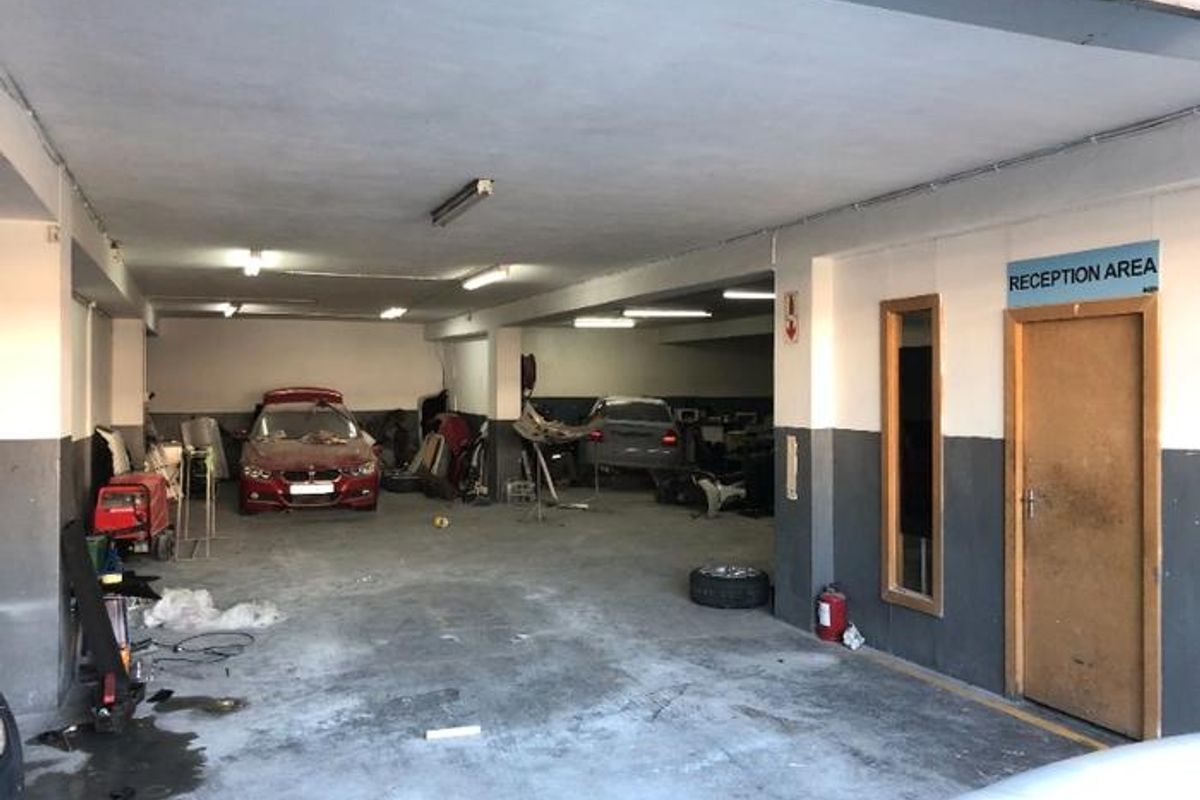 Spacious commercial garage or workshop area featuring concrete flooring, fluorescent lighting, and a dedicated reception access point.