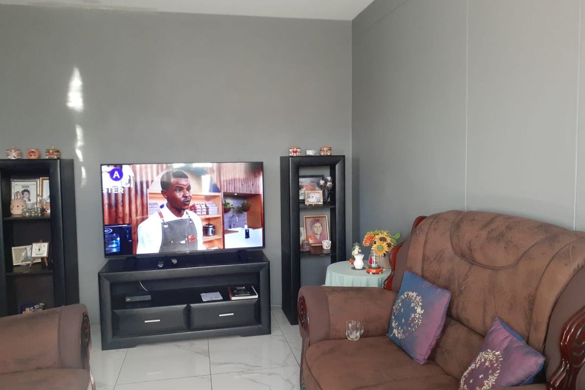 A living room featuring neutral grey walls and light-colored tiled flooring, providing a clean and functional space for relaxation.
